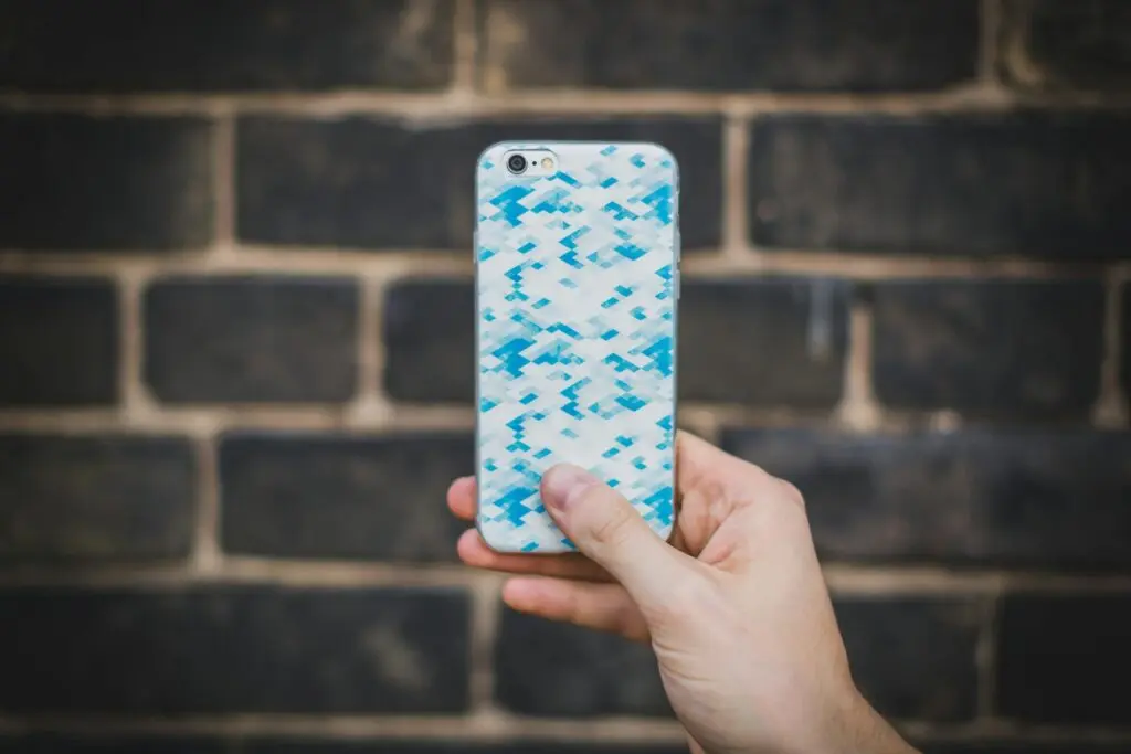 KKTC yenilenmiş iPhone almak güvenli mi — el ile iPhone tutan kişi